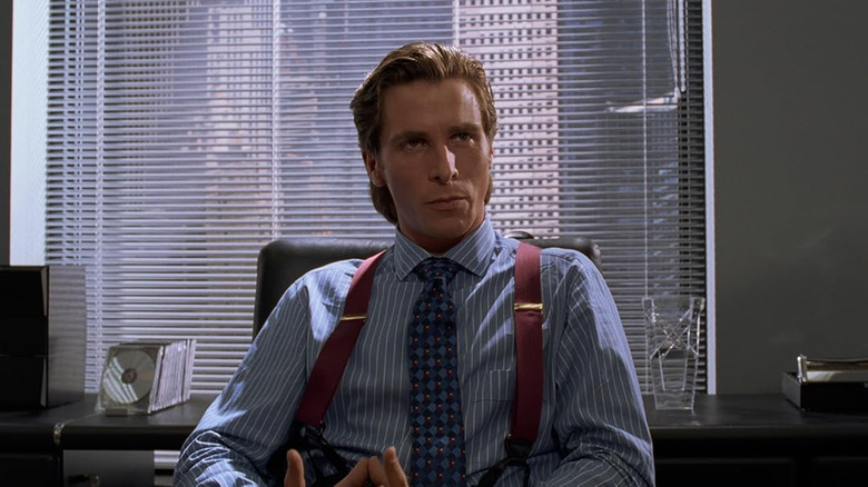 Christina Bale sitting at his office desk in American Psycho