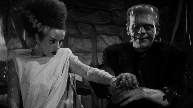 The Monster holds hands with the Bride of Frankenstein