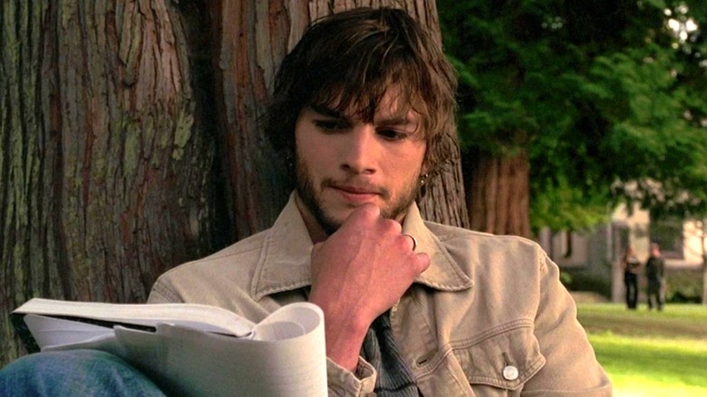 Ashton Kutcher as Evan Treborn reads his journal against a tree in The Butterfly Effect