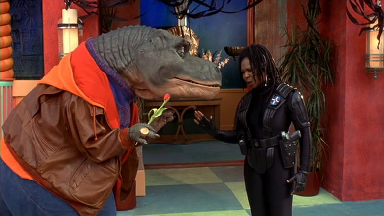 Whoopi Goldberg standing next to a T-Rex